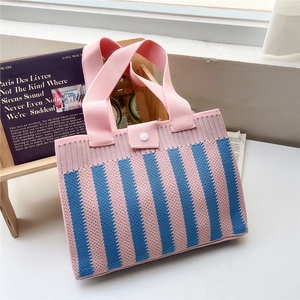 Detail of pink and blue striped knit tote bag showing thick texture and button closure