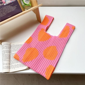 Macro view of flower knit tote bag showing orange polka dots and hollow texture