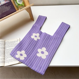 Detailed knit texture of purple tote bag with white flower patterns in home setting