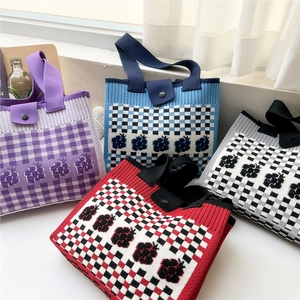 Knitted tote bag in checkerboard and floral patterns with top handles and metal snaps