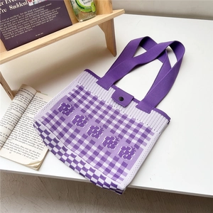 Detail of purple knitted tote bag with checkered pattern and decorative jacquard text
