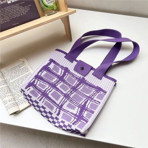 Dettaglio della borsa tote in maglia a scacchi viola e bianchi con chiusura a bottone