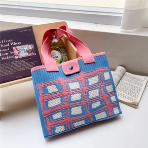 Dettaglio della borsa tote in maglia spessa con motivo a scacchi colorati e chiusura a scatto