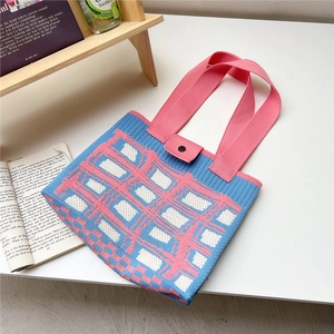 Dettaglio della trama a maglia della borsa tote a quadri rosa e blu con chiusura a bottone