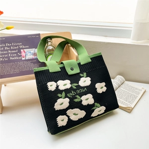 Detail of floral knit tote bag showing thick texture, button flap and 'Nice day' text