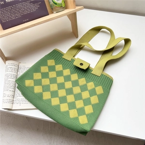 Detail of green knit tote bag with yellow checkerboard pattern and button closure