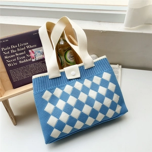 Detail of blue checkerboard knit tote bag featuring woven texture and snap button closure