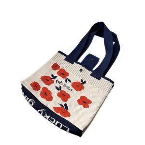 Knitted floral tote bag with poppy patterns and nice day text in a 45-degree angle view