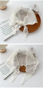 Detail of white lace triangle scarf featuring intricate floral crochet and wavy edges