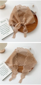 Close-up of light brown floral lace scarf with delicate scalloped edges and pattern