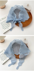 Close-up of light blue lace scarf with mesh texture and elegant wavy scalloped edges