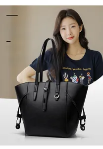 Detail view of premium black pebbled leather tote bag with functional metal buckles