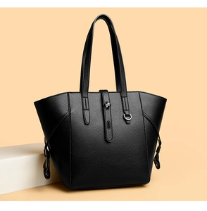 Close-up of black lychee grain tote bag showing decorative buckles and tassel details