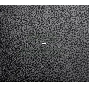 Close-up of black lychee grain texture on durable leather tote bag surface