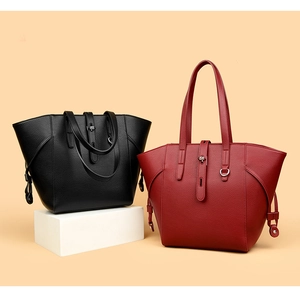 Detail of minimalist leather tote bags in black and wine red with lychee texture