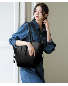 Detail of black large tote bag with lychee grain texture and side adjustment straps