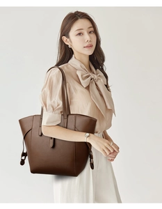 Close-up of dark brown tote bag showing premium lychee grain leather and side tie details