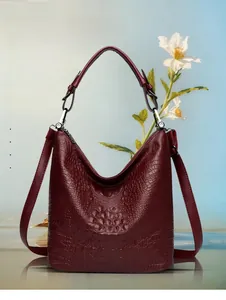 Detail of burgundy crocodile-embossed leather tote with silver buckle and large capacity