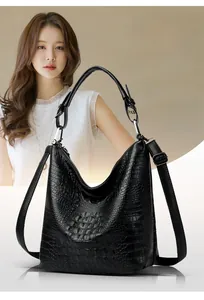 Model wearing black crocodile pattern PU leather hobo bag with silver hardware and shoulder strap