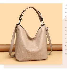 Detail of beige crocodile pattern tote bag with top handle and adjustable shoulder strap
