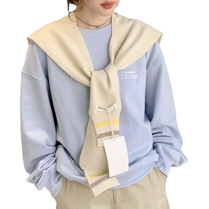 Light blue sweatshirt styled with a beige knitted striped shawl and brand label