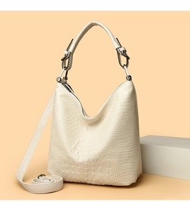 Detail of cream crocodile embossed hobo bag with adjustable strap and metallic hardware