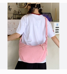 Detailed back view of a pink corduroy dumpling bag with woven zipper pull for women