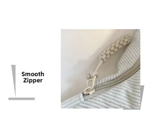 Close-up of high-quality smooth zipper on a beige corduroy crossbody dumpling bag