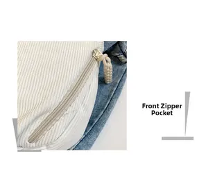 Detailed view of white corduroy dumpling bag featuring front zipper with woven puller