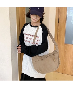 Detailed view of the brown corduroy crossbody bag texture with stylish woven zipper pull