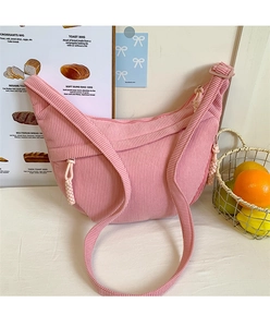 Detailed texture of pink corduroy fabric on a crescent crossbody bag with adjustable strap