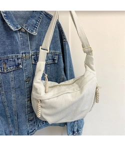 Detail of cream corduroy crescent bag showing fabric texture and woven zipper puller