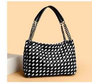 Vue détaillée du sac tissé à damier noir et blanc avec poignées en cuir et chaîne