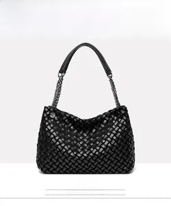 Gros plan sur la texture tressée noire et la chaîne métallique du sac à main