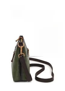 Detail of adjustable shoulder strap buckle on dark green faux leather crossbody bag