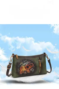 Detailed close-up of retro green leather crossbody bag with embossed elephant pattern