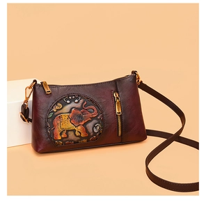 Close-up of vintage dark red crossbody bag with ethnic elephant embossed detail