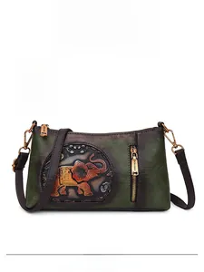 Detailed view of dark green leather shoulder bag featuring embossed elephant texture