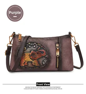 Close-up of vintage purple crossbody bag featuring elephant embossing and metallic zipper