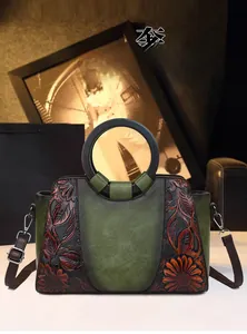 Detail of vintage tote bag featuring embossed sunflower patterns and wooden ring handles
