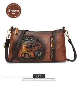 Detail of vintage brown textured leather crossbody bag with embossed elephant and floral design