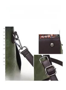 Detail of dark green leather tote with silver hardware and vintage textured embossing