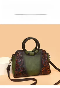 Close-up of vintage tote bag featuring dark green leather and brown floral embossing