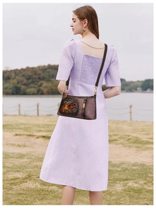 Brown leather crossbody bag detail featuring ethnic elephant relief and pebble texture