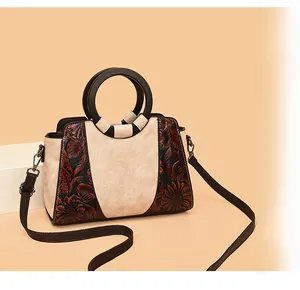 Macro view of vintage tote bag with floral embossing and black round handles
