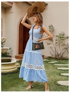 Detail view of dark green crossbody bag with ethnic elephant pattern on blue dress
