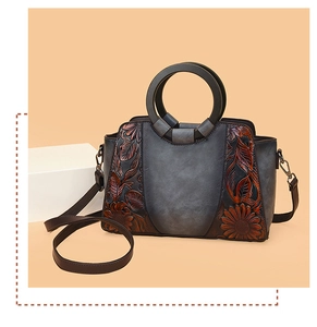 Detailed relief of chrysanthemum flowers on vintage brown leather tote bag with handle
