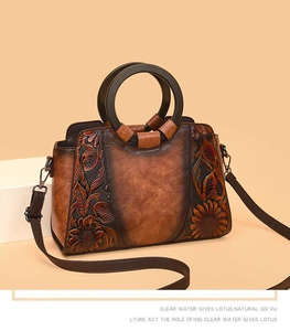 Close-up of vintage brown leather bag with sunflower embossing and round wooden handles
