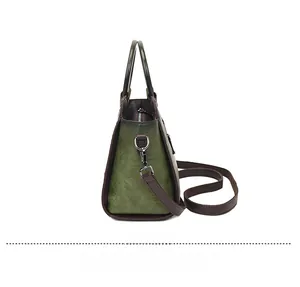 Side view of retro green leather handbag with brown trim and adjustable strap