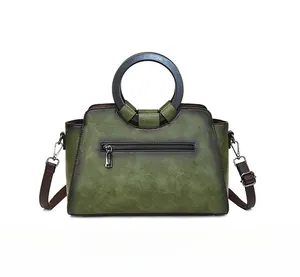Rear view of vintage green tote with round handle and functional zipper pocket detail